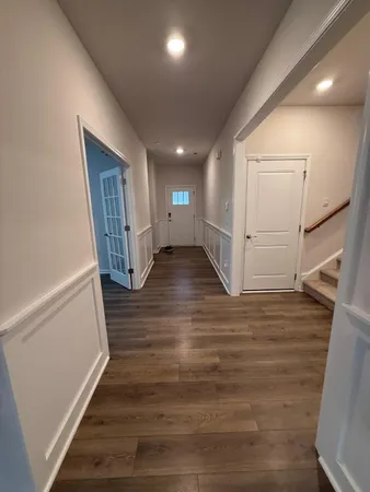 a view of hallway with stairs and wooden floor