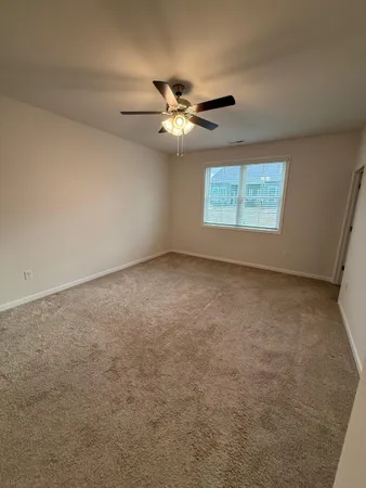 an empty room with windows and fan