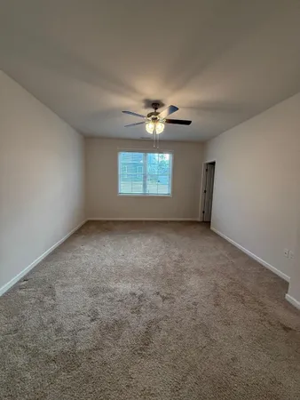 an empty room with windows and fan