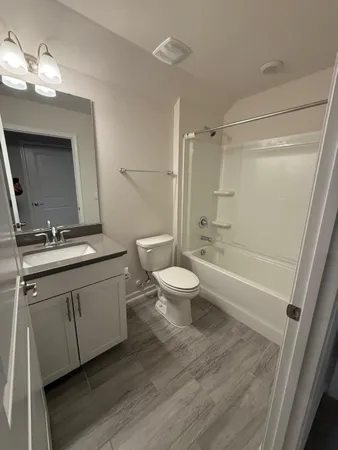 a bathroom with a double vanity sink toilet mirror and shower