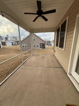 a view of a porch with furniture and a yard