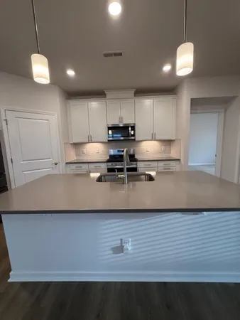 a kitchen with kitchen island a sink stainless steel appliances and cabinets