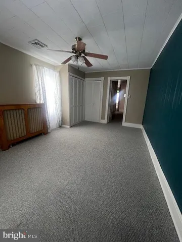 a view of a livingroom with a ceiling fan and window