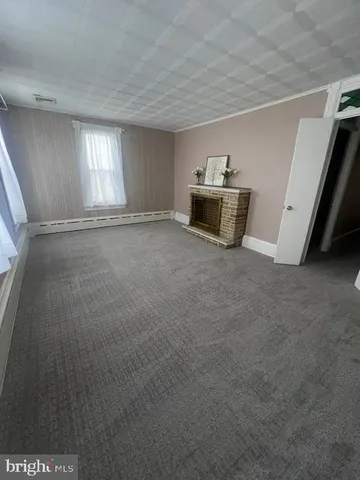 a view of empty room with kitchen
