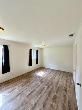 a view of empty room with wooden floor