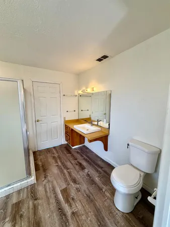 a bathroom with a sink toilet a mirror and shower