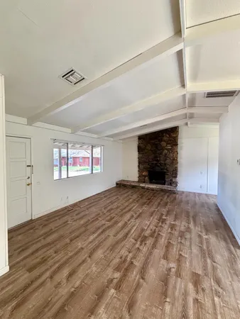 a view of empty room with wooden floor and fireplace