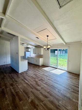 a view of empty room with wooden floor and fireplace