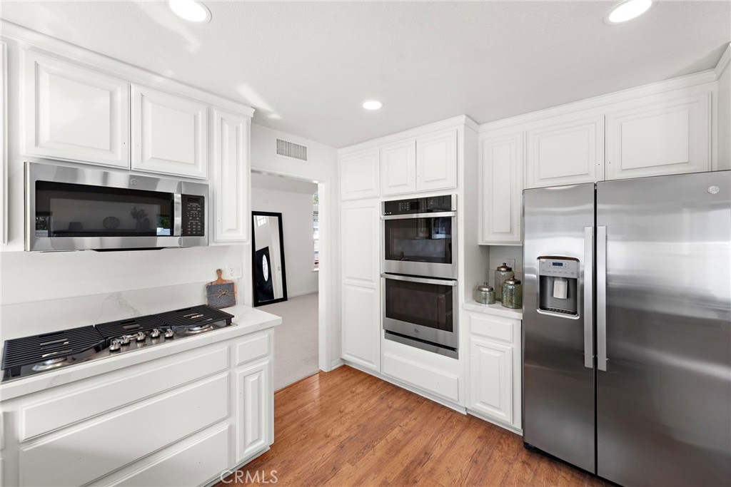 27552 Seascape Circle Dana Point, CA 92624 - Photo 4 of 39 a kitchen with stainless steel appliances and white cabinets