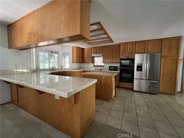 a kitchen with stainless steel appliances granite countertop a sink a stove a microwave and a refrigerator