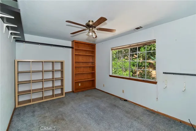 a view of a livingroom with a staircase and a ceiling fan