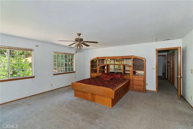 a bedroom with a bed and a large window