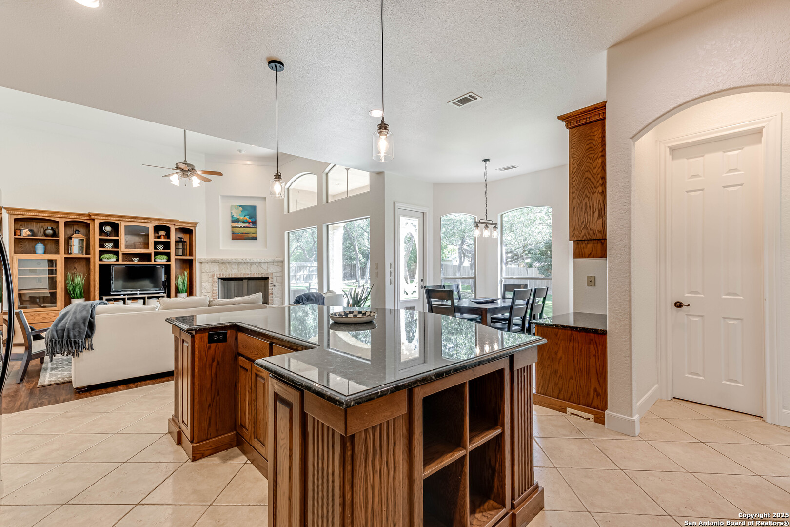 132 Long Bow Road Shavano Park, TX 78231 - Photo 16 of 50 a kitchen island with granite countertop a sink and a refrigerator