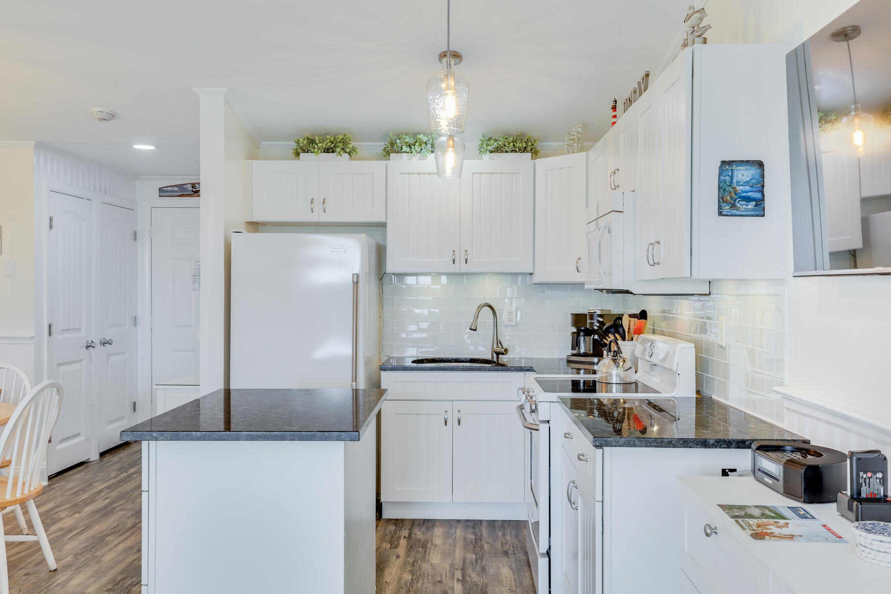 132 Shore Road, Unit 48 Truro, MA 02666 - Photo 9 of 35 a kitchen with stainless steel appliances a refrigerator sink and white cabinets