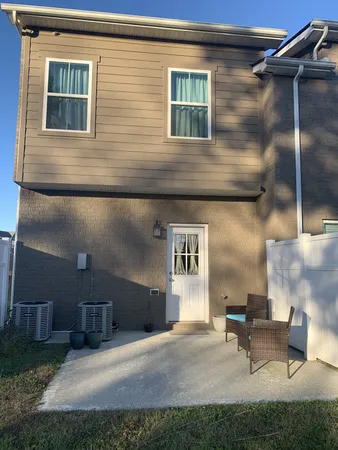 a couple of table and chairs in patio of house