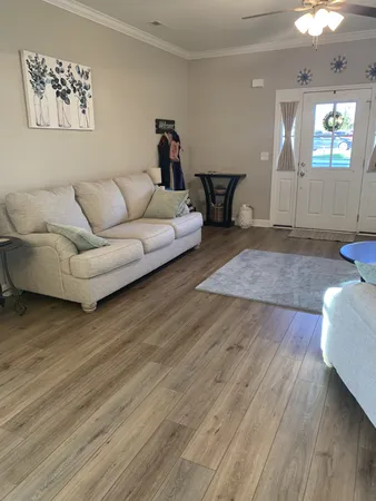 a living room with furniture and a wooden floor