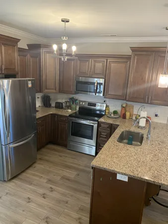 a kitchen with granite countertop a sink stainless steel appliances and cabinets