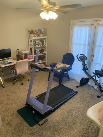 a room with gym equipment and a chandelier