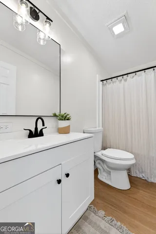 a bathroom with a toilet a sink and mirror