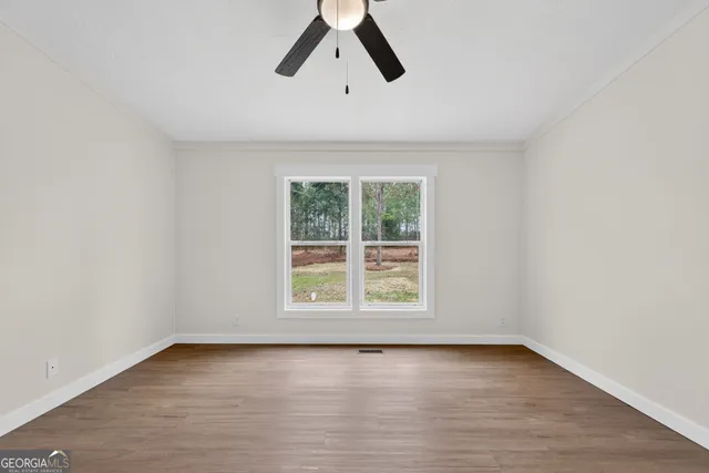 an empty room with a window and a ceiling fan