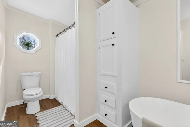 a bathroom with a toilet a sink and a mirror