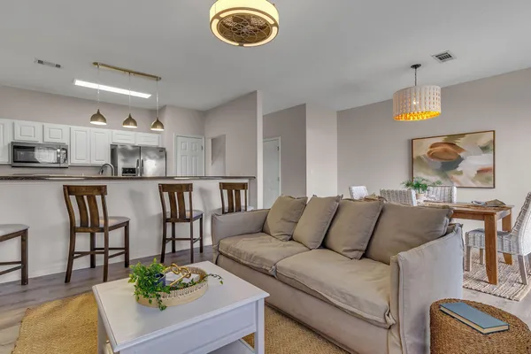 a living room with furniture kitchen and a chandelier