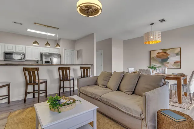 a living room with furniture kitchen and a chandelier