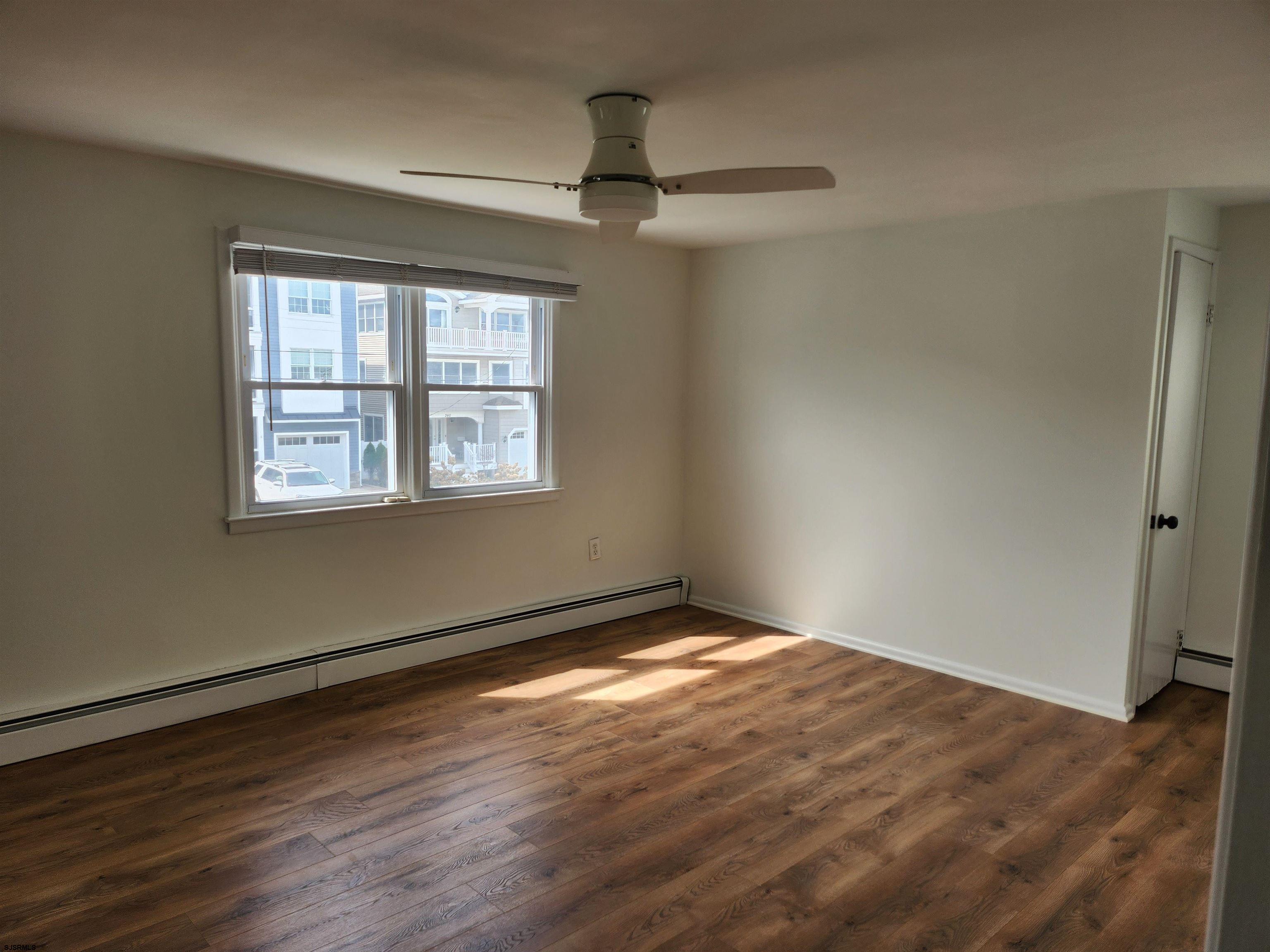 353 11th Street South, Unit 2 Brigantine, NJ 08203 - Photo 11 of 17 a view of an empty room with wooden floor and a window