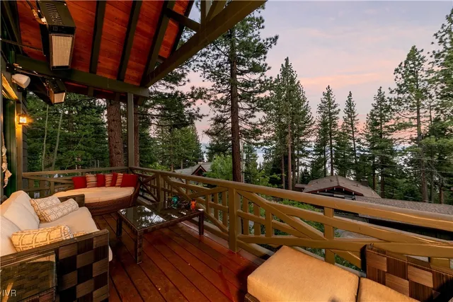 a view of a patio with table and chairs with wooden floor and fence