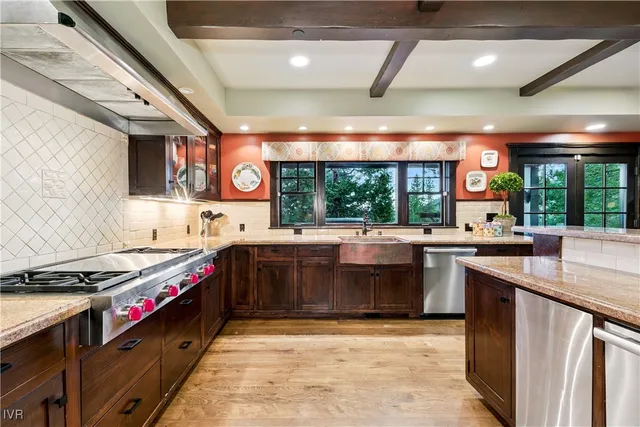 a kitchen with stainless steel appliances granite countertop a stove a sink and a microwave