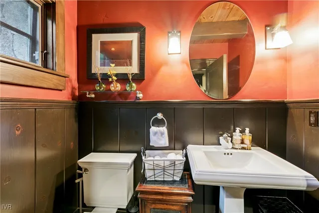 a bathroom with a sink mirror and toilet