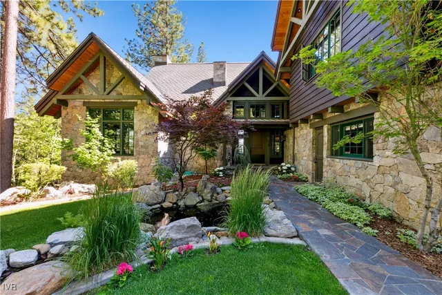 a view of a house with a small yard and flower plants