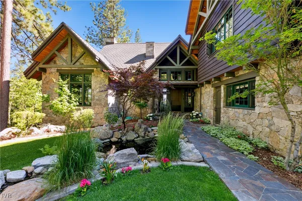 a view of a house with a small yard and flower plants