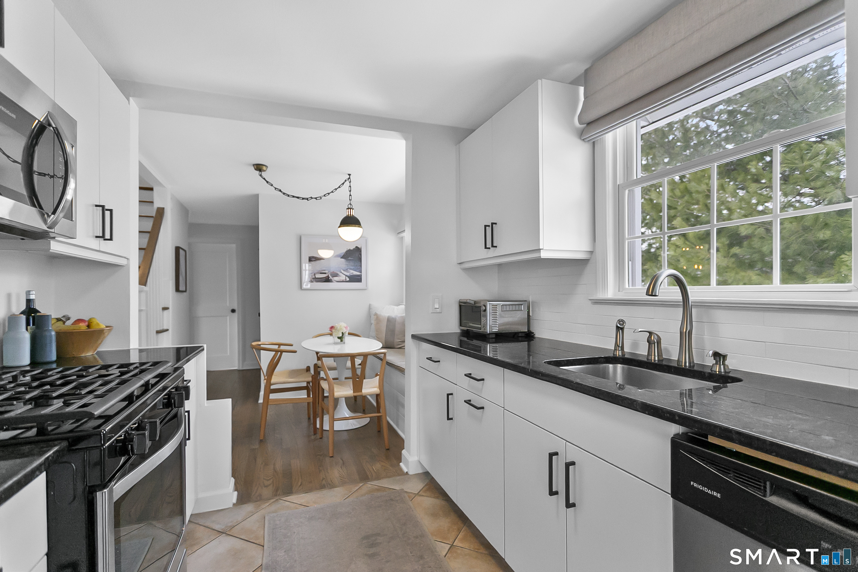 121 Alden Street Fairfield, CT 06824 - Photo 11 of 29 a kitchen with granite countertop a stove a sink dishwasher and cabinets with wooden floor