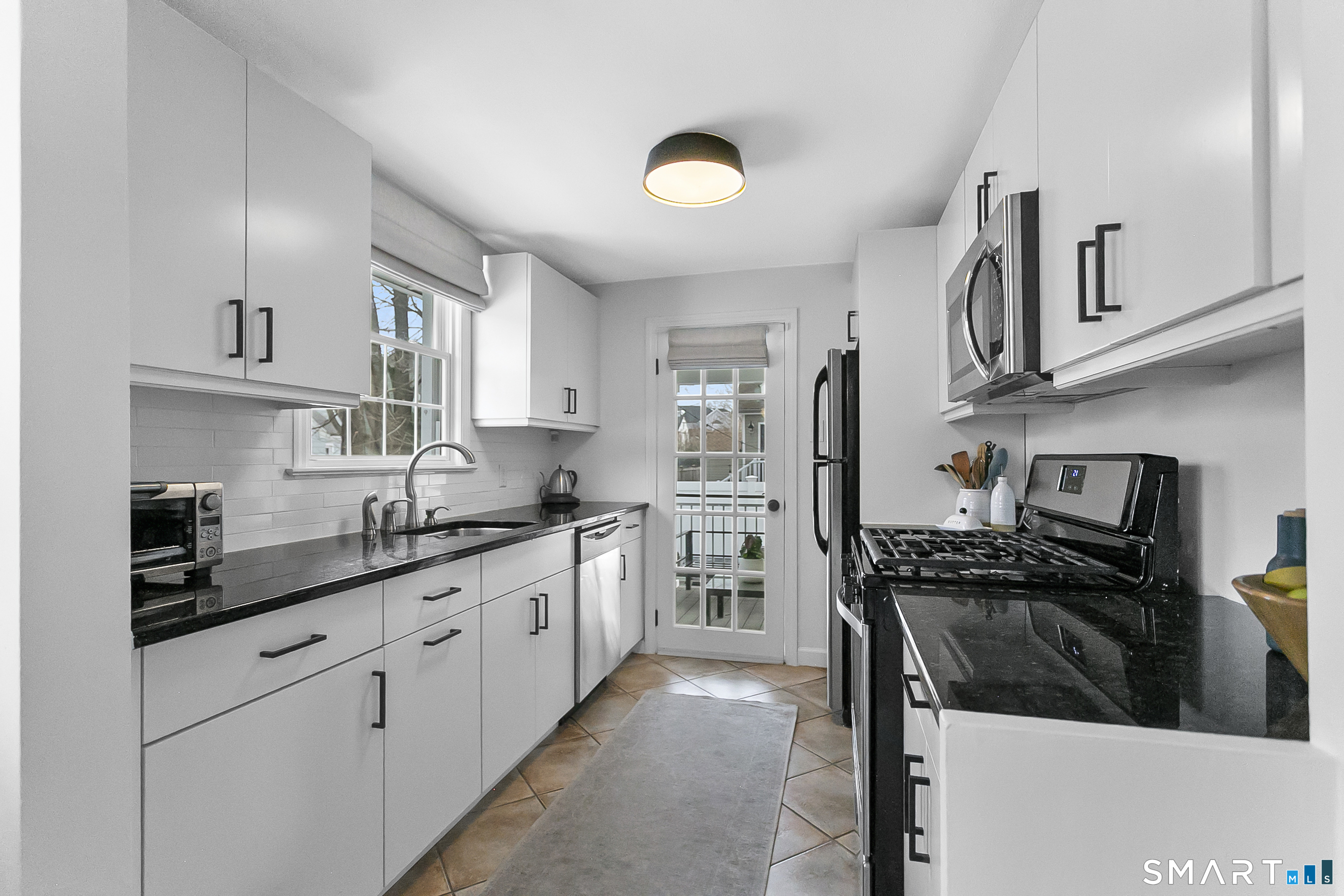 121 Alden Street Fairfield, CT 06824 - Photo 13 of 29 a kitchen with stainless steel appliances a sink stove refrigerator and cabinets