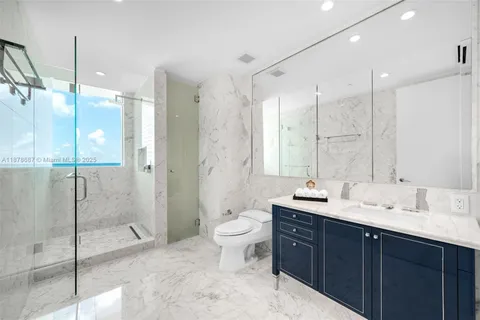 a bathroom with a double vanity sink toilet mirror and shower