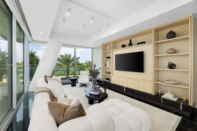 a living room with furniture potted plant and a flat screen tv