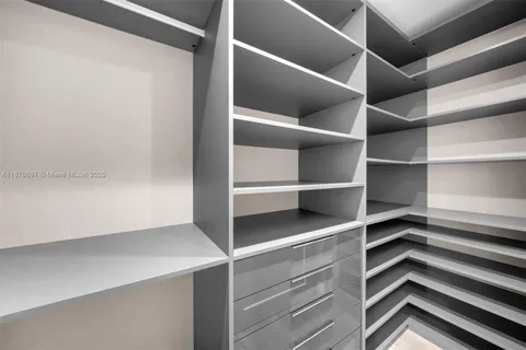 a view of walk in closet with empty racks