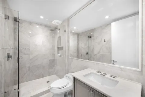 a bathroom with a sink vanity granite toilet and shower