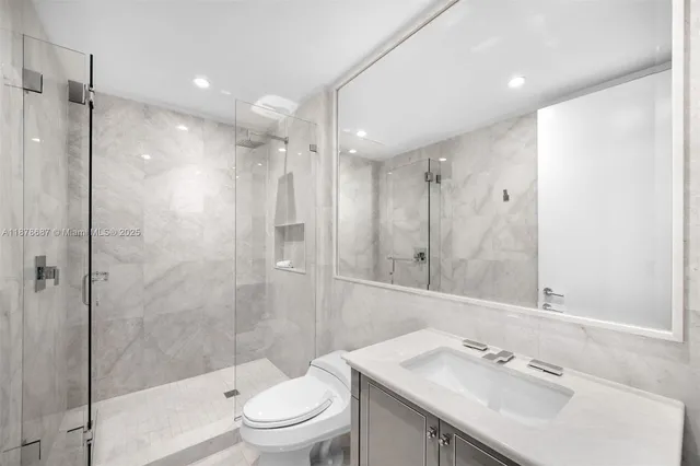 a bathroom with a sink vanity granite toilet and shower