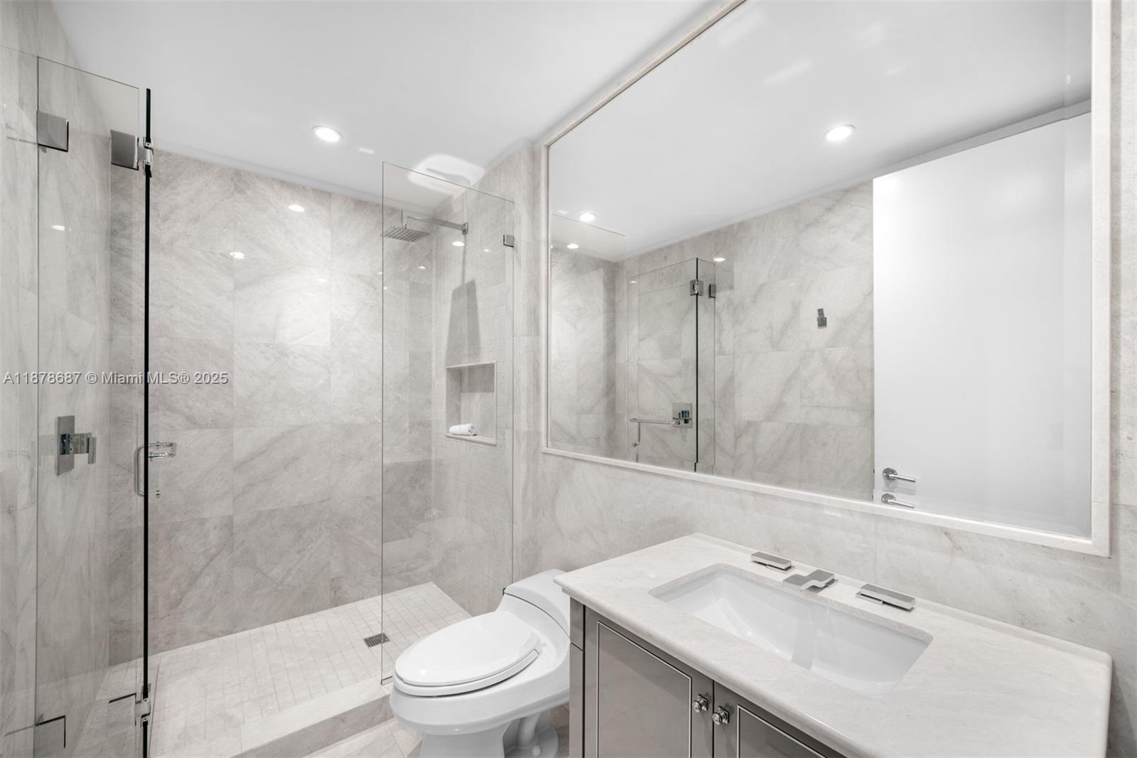 9349 Collins Avenue, Unit 406 Surfside, FL 33154 - Photo 25 of 48 a bathroom with a sink vanity granite toilet and shower