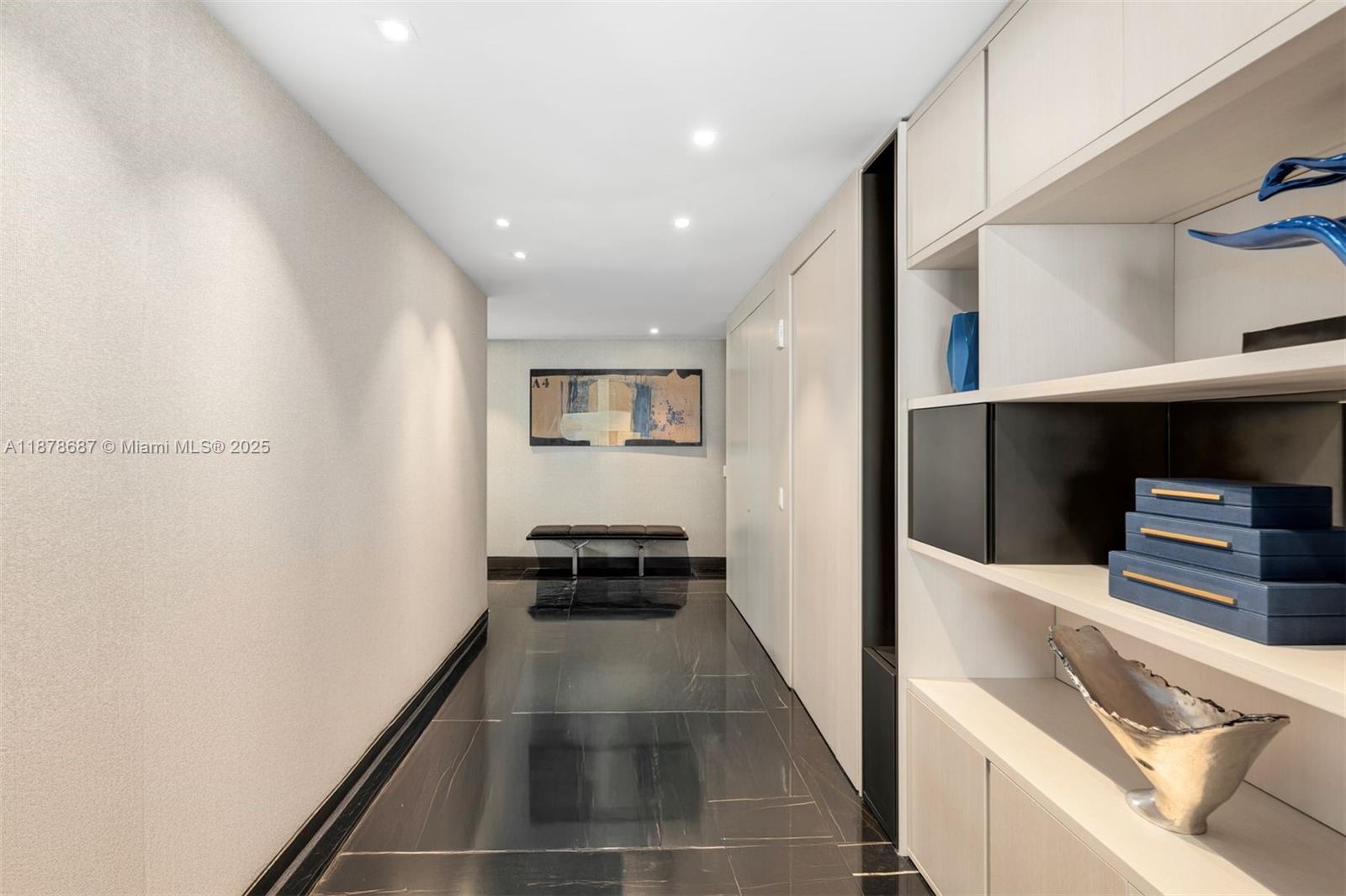 9349 Collins Avenue, Unit 406 Surfside, FL 33154 - Photo 30 of 48 a hallway with white cabinets and black appliances