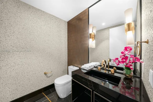 a bathroom with a sink mirror vanity and toilet