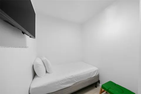 a bedroom with a bed and a white wall