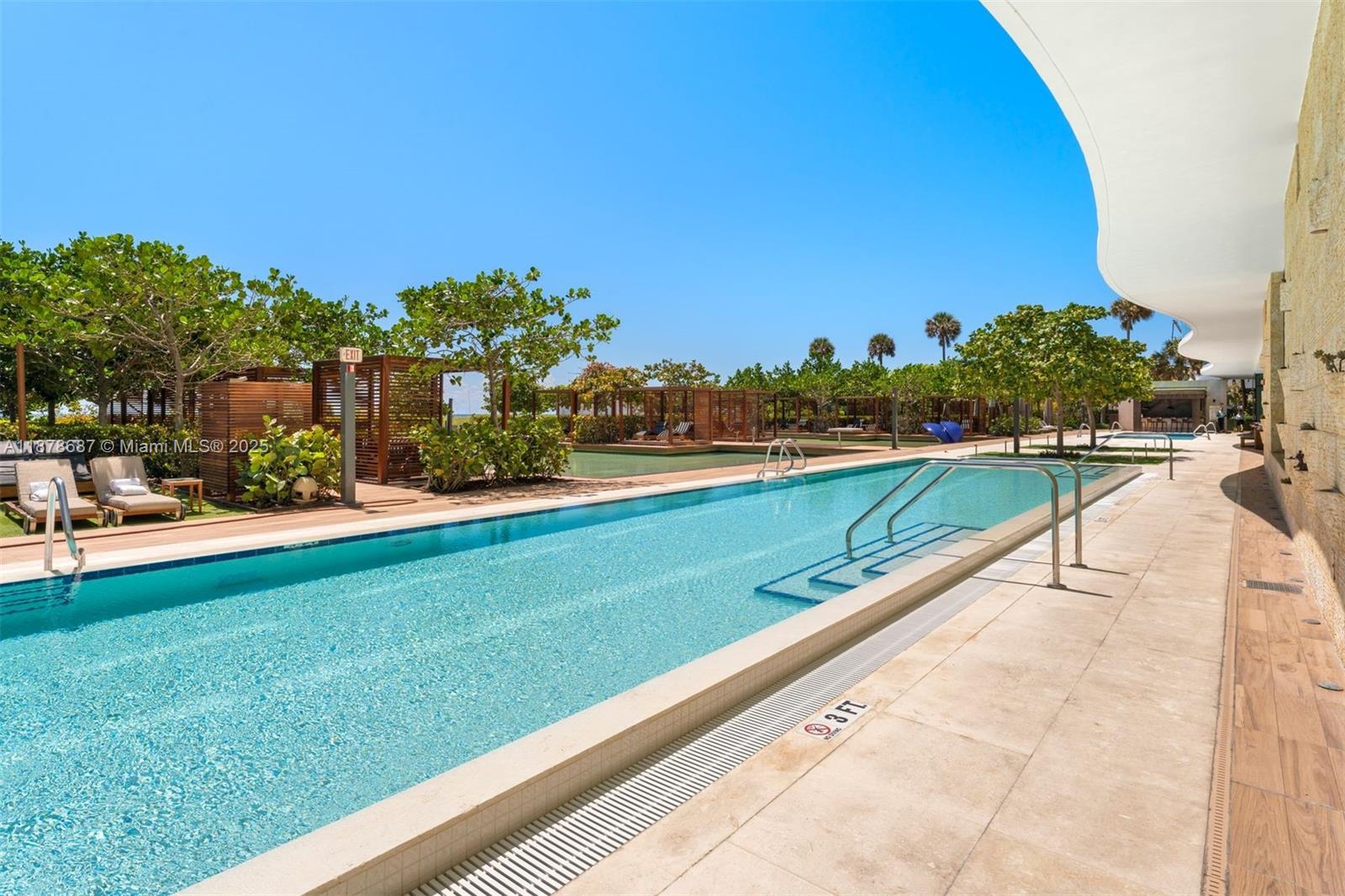 9349 Collins Avenue, Unit 406 Surfside, FL 33154 - Photo 43 of 48 a view of swimming pool with outdoor seating and lake view