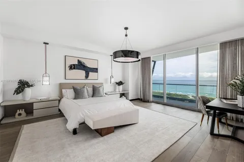 a spacious bedroom with a bed a chandelier and large window