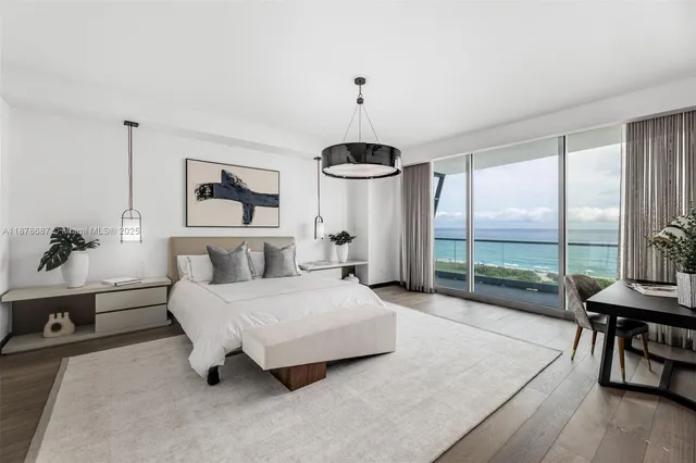 a spacious bedroom with a bed a chandelier and large window