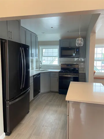 a view of an empty room with wooden floor and closet