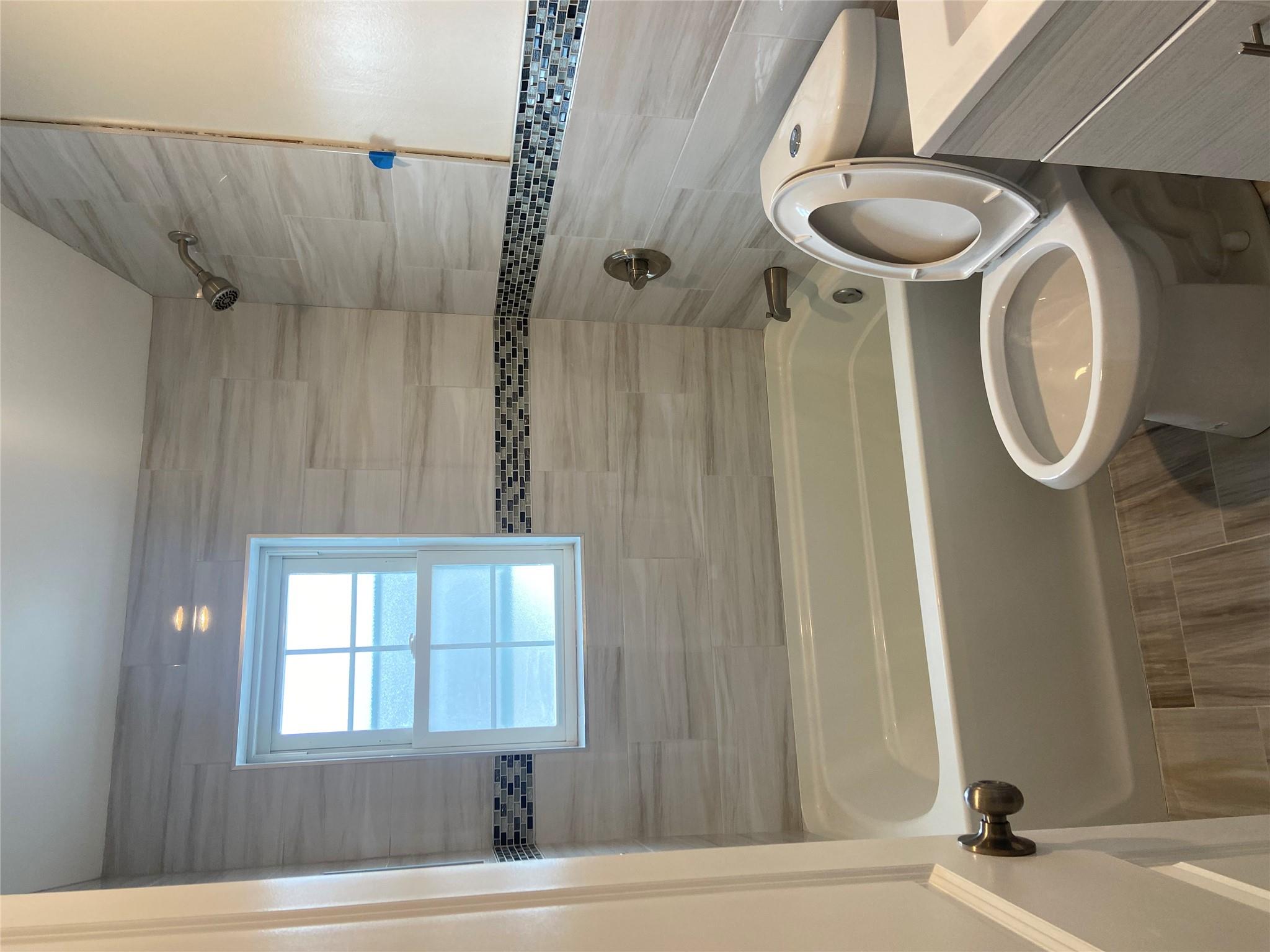 157-18 115th Road, Unit 2 FAMILY Queens, NY 11434 - Photo 30 of 36 a bathroom with a sink a toilet and a bathtub