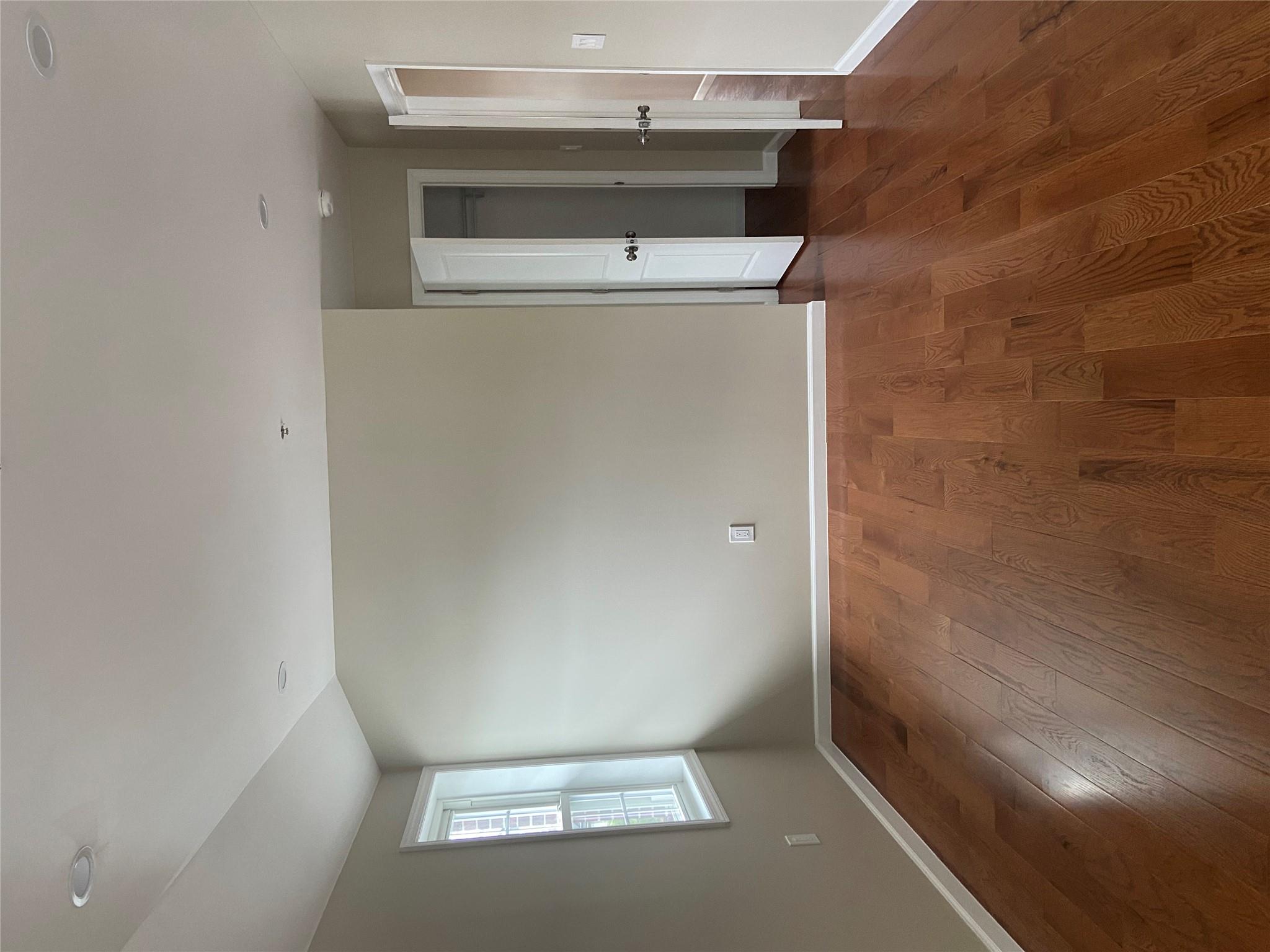 157-18 115th Road, Unit 2 FAMILY Queens, NY 11434 - Photo 33 of 36 an empty room with wooden floor and windows